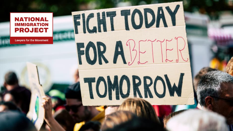 A photograph of a cardboard sign amongst protesters. The sign reads "Fight today for a better tomorrow" written in black block letters in marker with "better" written in red hand script. The National Immigration Project logo is in the top left corner.